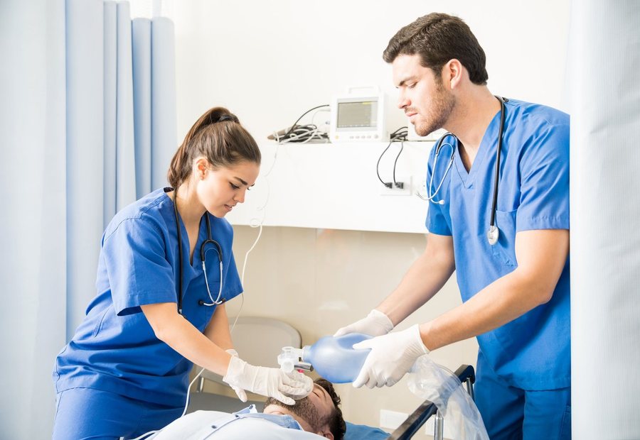 Two clinicians practising airway management on a training manikin