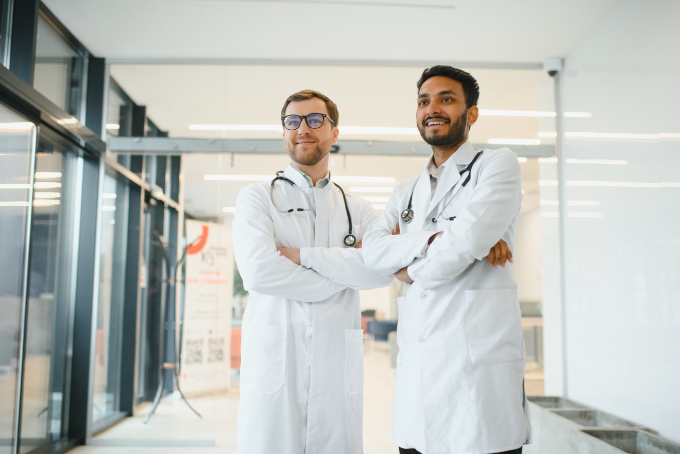 Two physicians in white coats in a modern hospital lobby