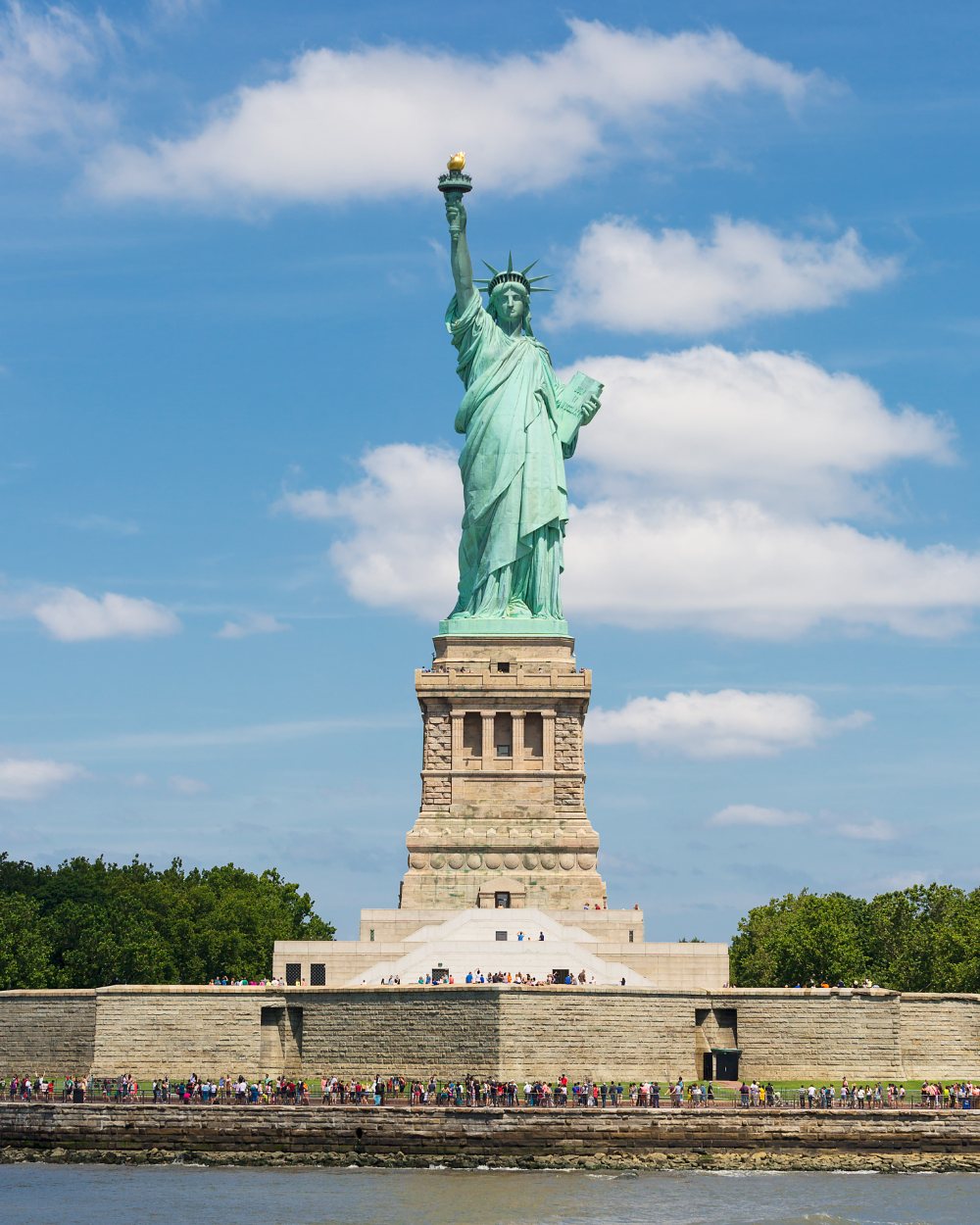 The Statue of Liberty on Liberty Island against a bright sky
